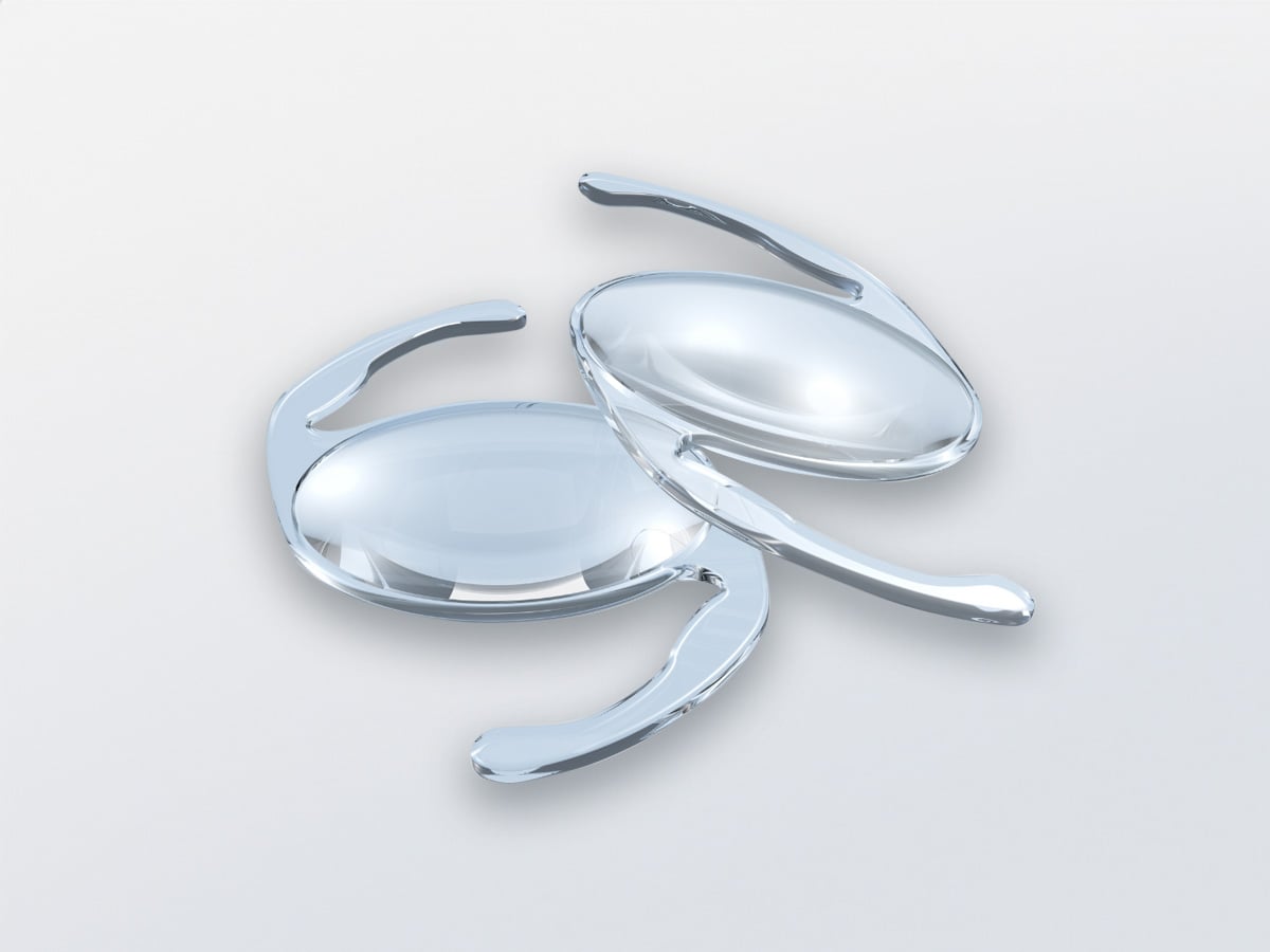 Three lenses with curved arms, arranged loosely on a light grey background