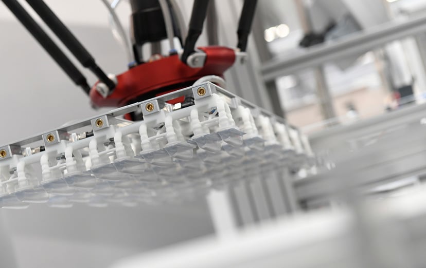 Delta robot gripper with a grid of suction cups holding multiple small products simultaneously