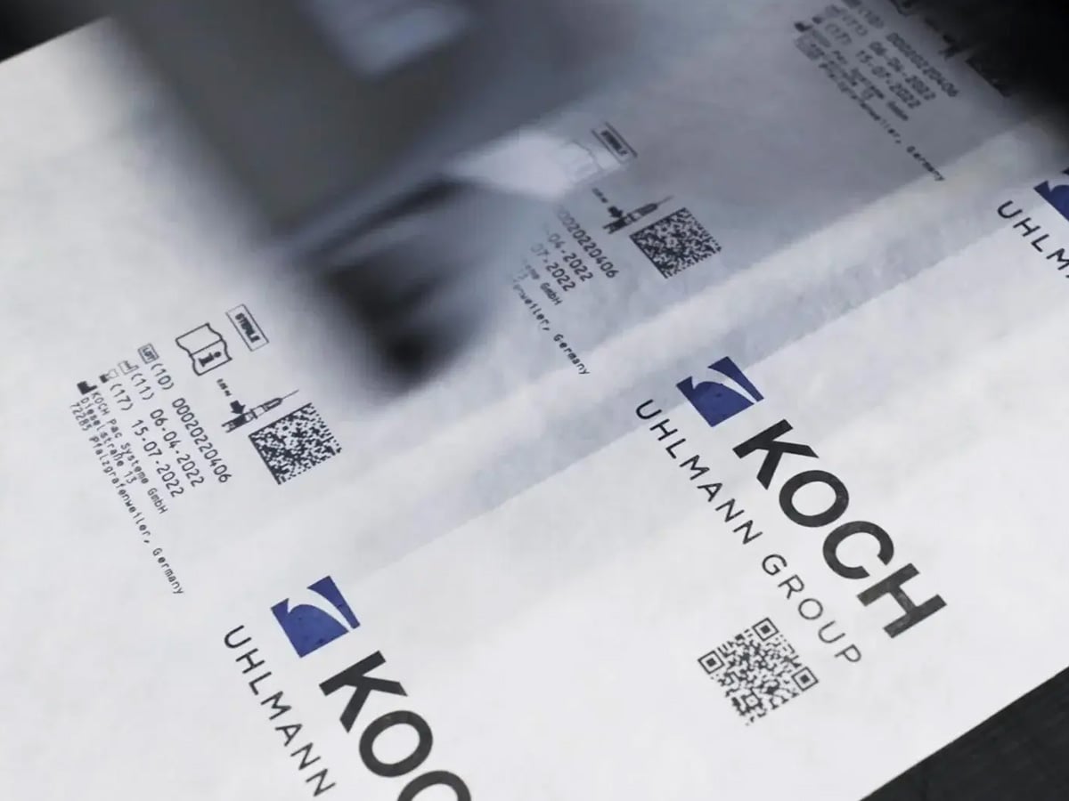 Packaging with printed batch data, QR codes and KOCH Uhlmann Group logo, illustrating automated labelling