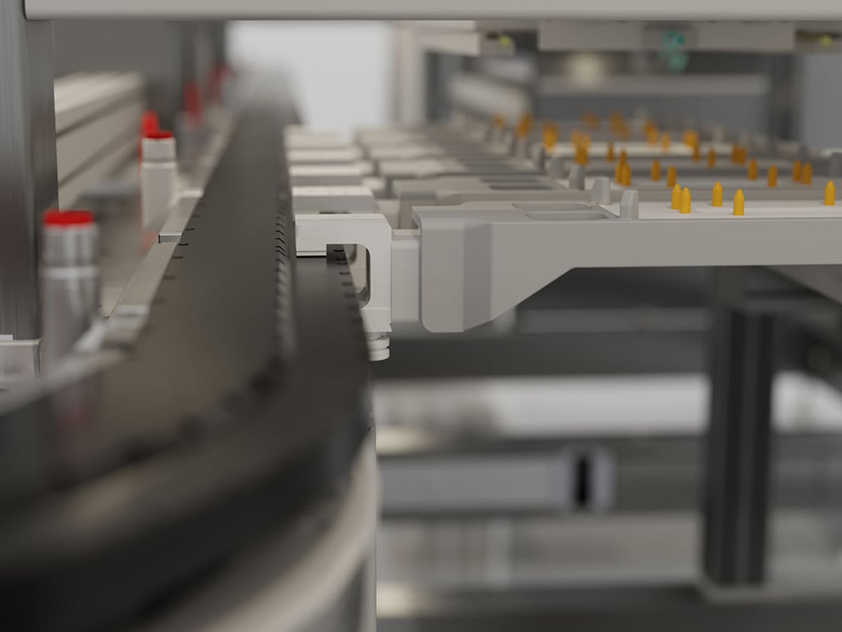 Linear transport system with product carriers and positioning pins, viewed along the conveyor length