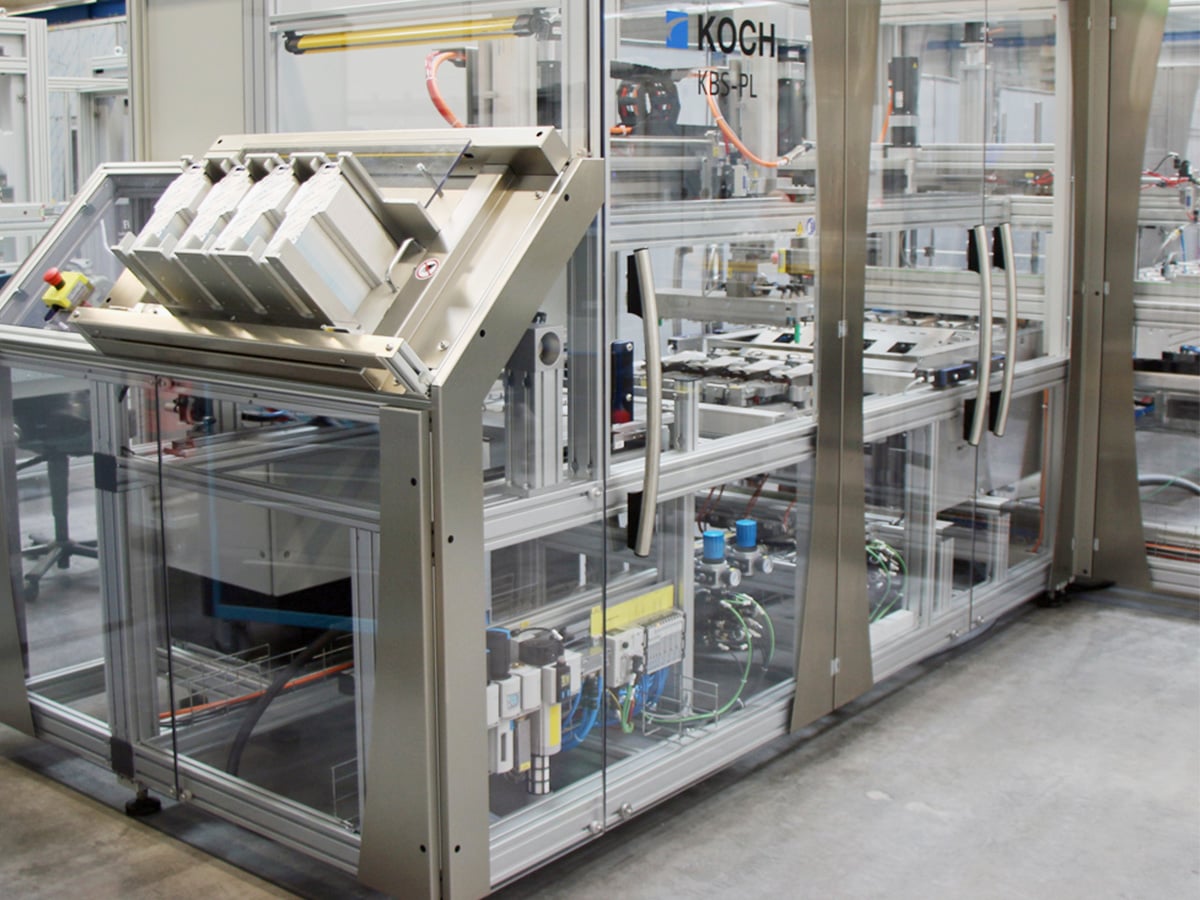 Carton magazine with four filled compartments on the infeed side of a packaging machine