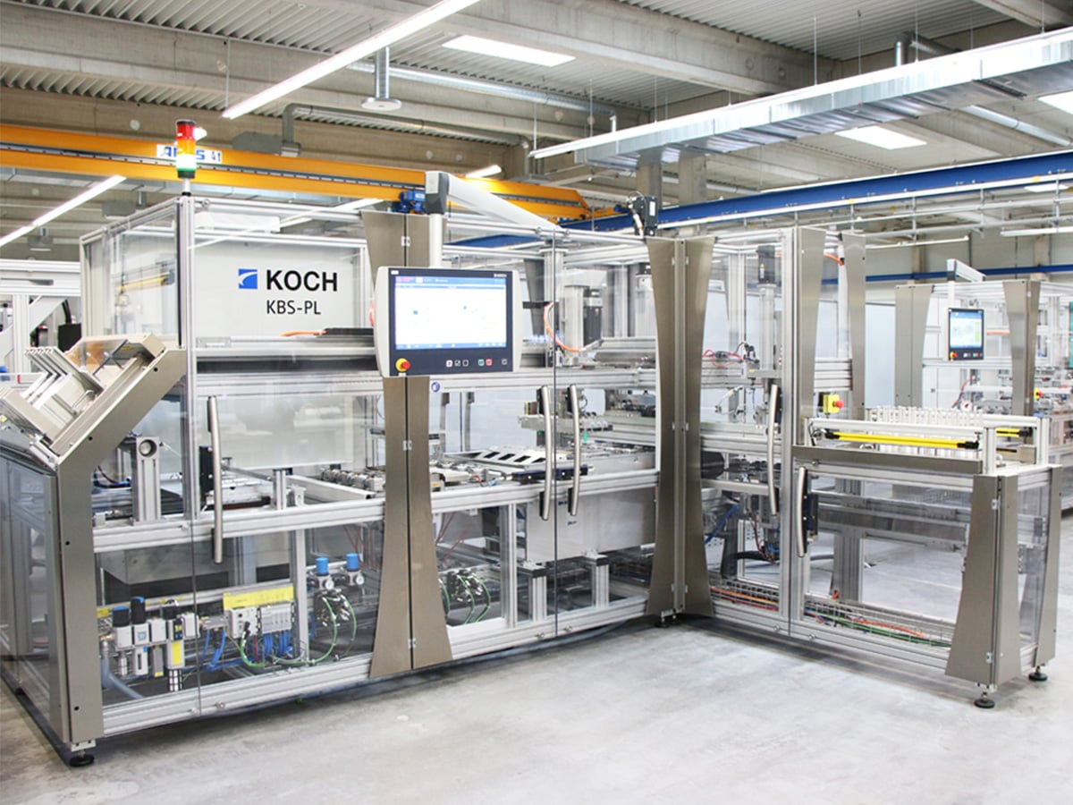 KOCH KBS-PL packaging machine with operator terminal and signal tower in a production hall