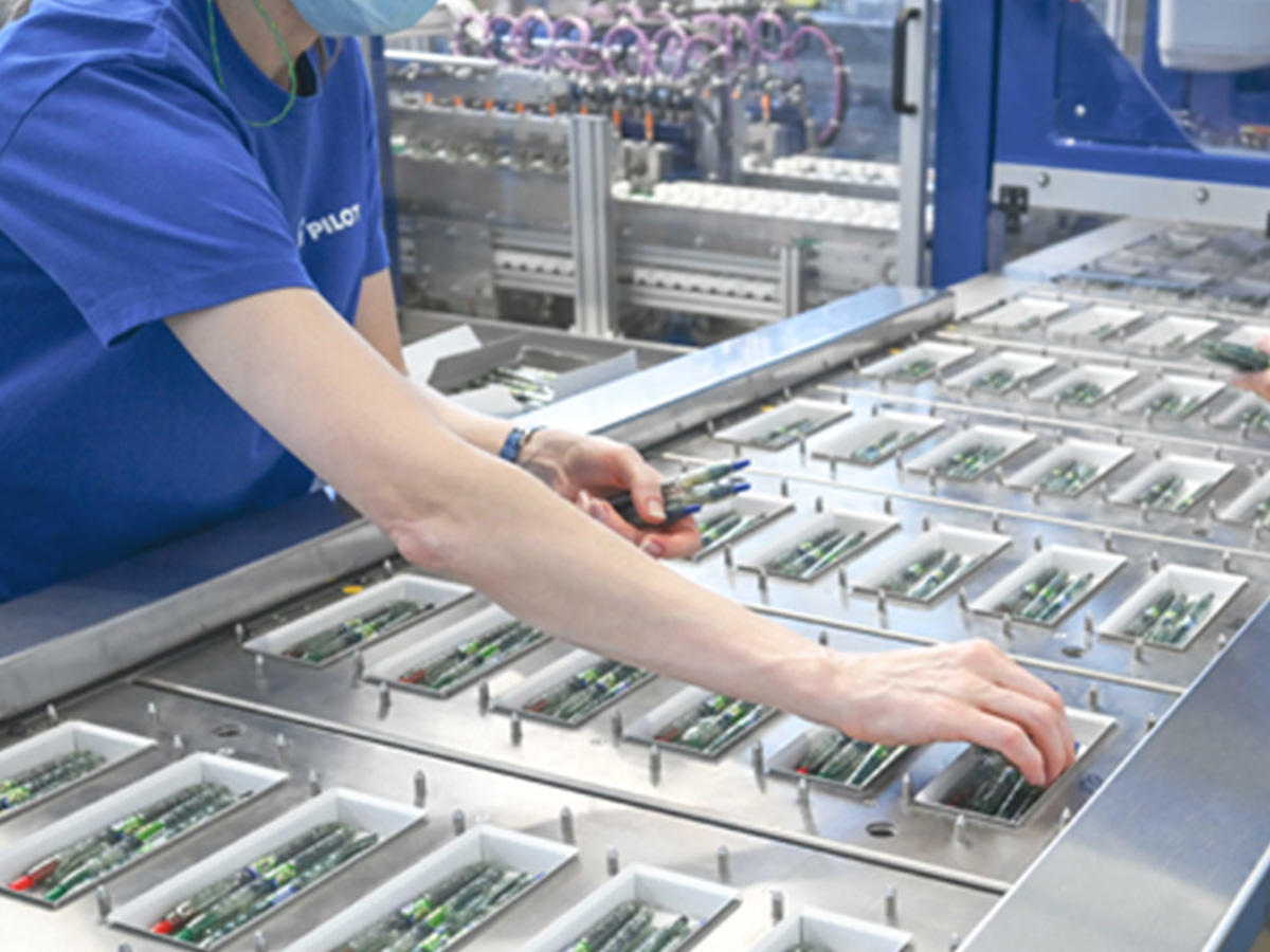 Pens being placed into blister packaging by hand