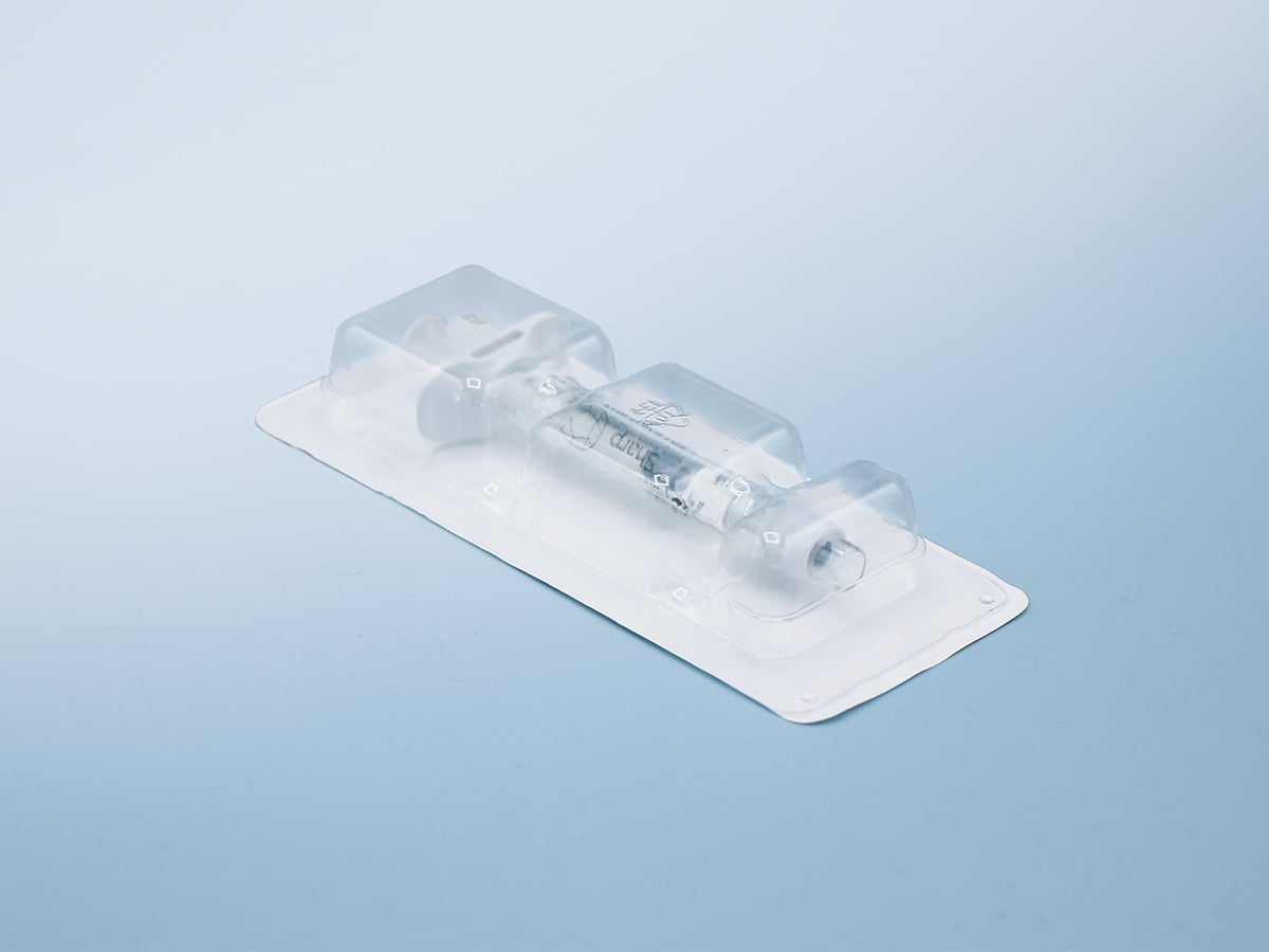 Sealed transparent blister holding a Sharp-labelled syringe with barrel, finger ring and plunger