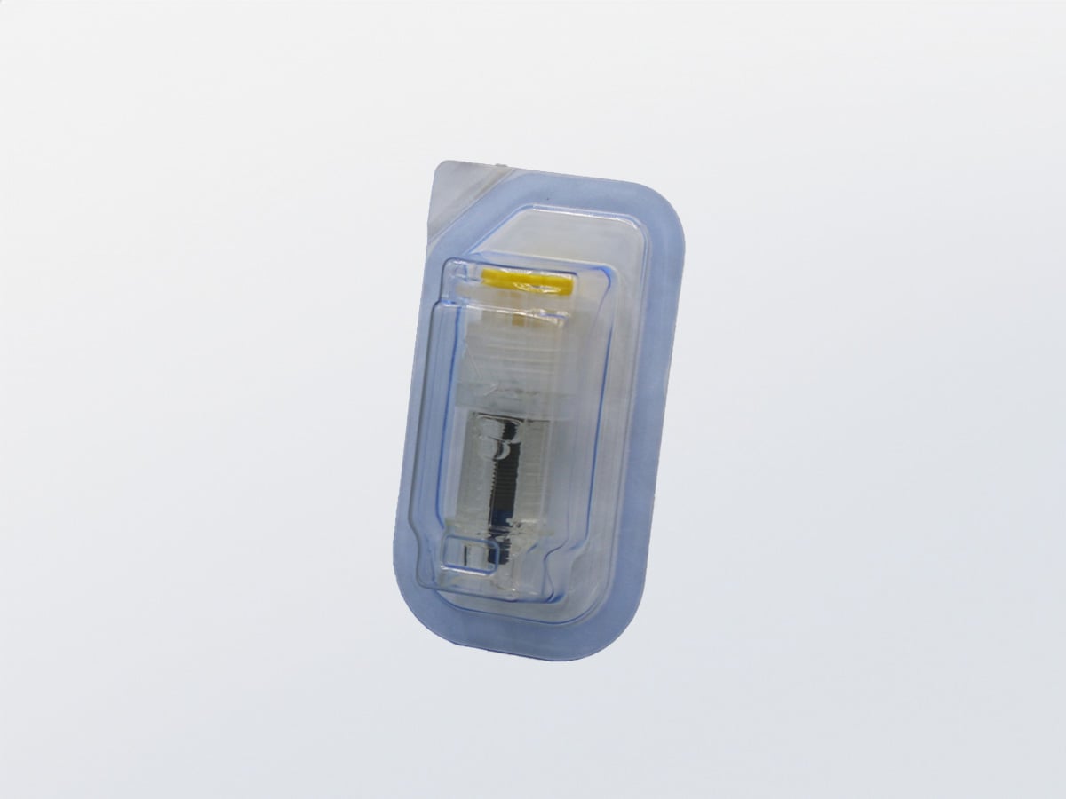 Sealed blue blister holding a small vial with a yellow cap, in sterile final packaging