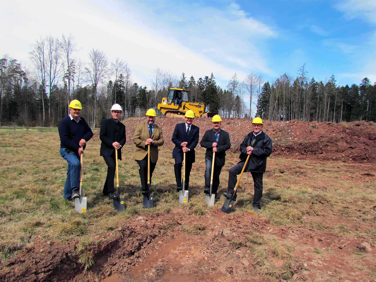Ground-breaking ceremony for the assembly hall extension in Pfalzgrafenweiler in 2012, with five people holding spades