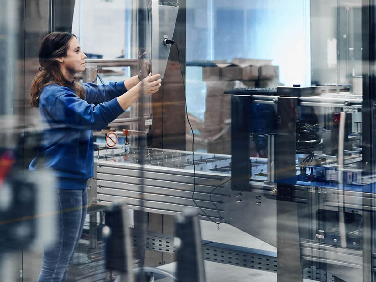 Employee working on a packaging machine in a production environment at KOCH Pac-Systeme, illustrating the company's innovation approach
