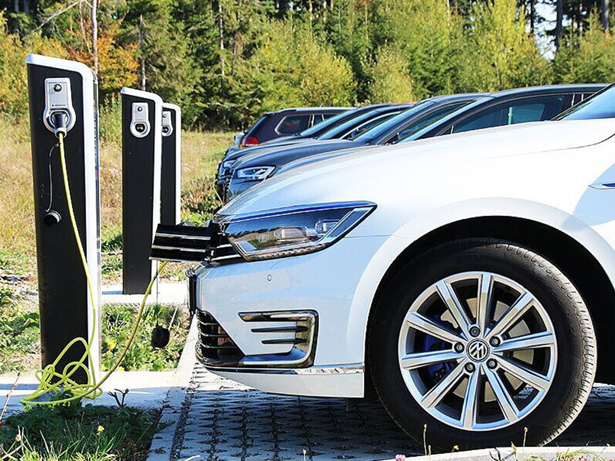Electric car charging at a charging station in a car park, illustrating KOCH Pac-Systeme's commitment to promoting e-mobility