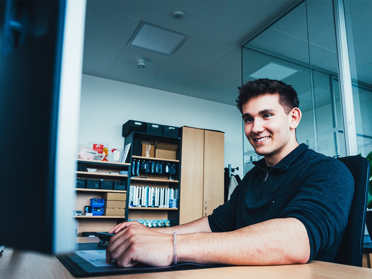 Young man working at a computer in an office environment, representing the IT Specialist for Data and Process Analysis apprenticeship at KOCH Pac-Systeme