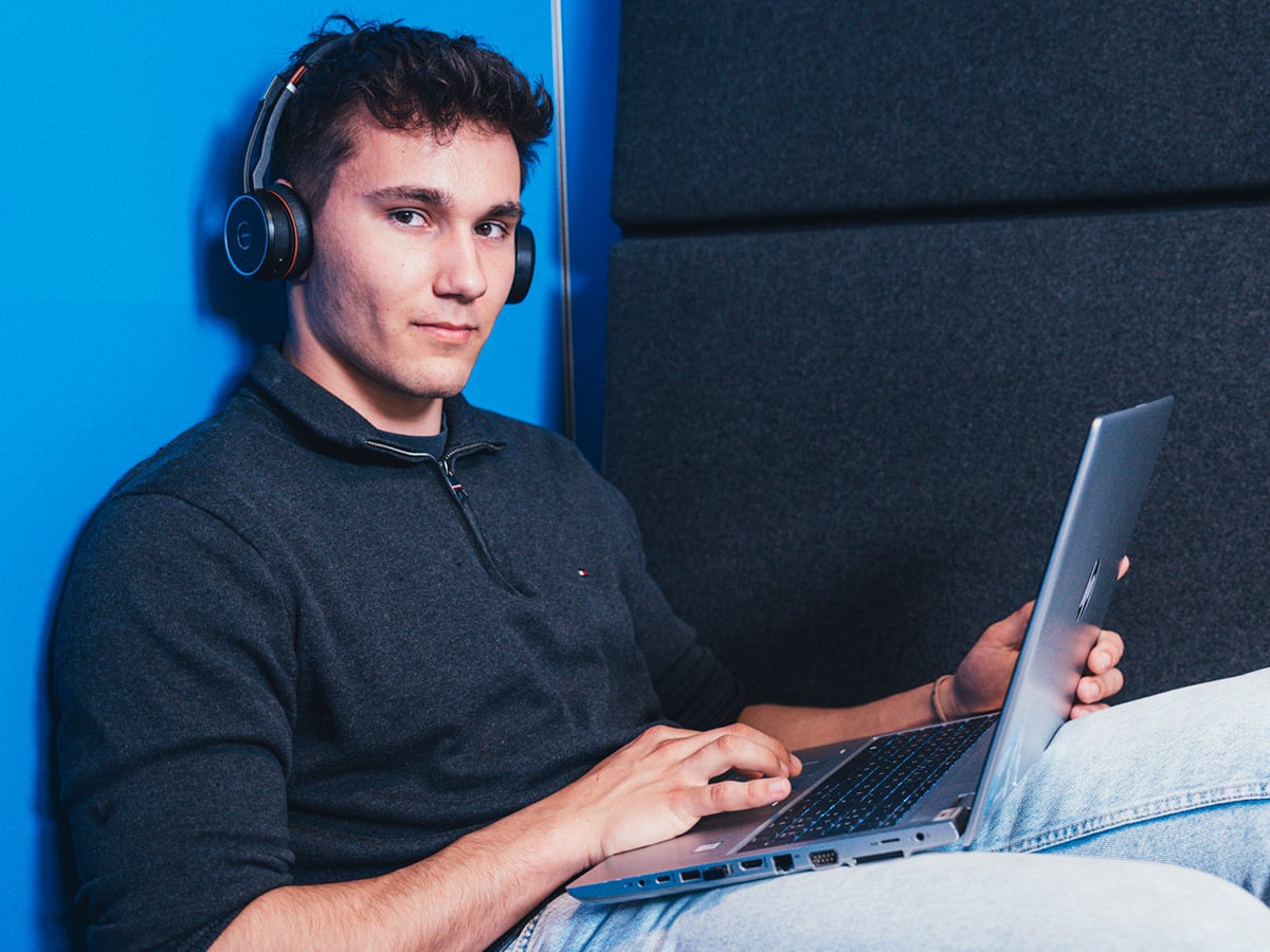 Young man with headphones and a laptop, representing the IT Specialist for System Integration apprenticeship at KOCH Pac-Systeme