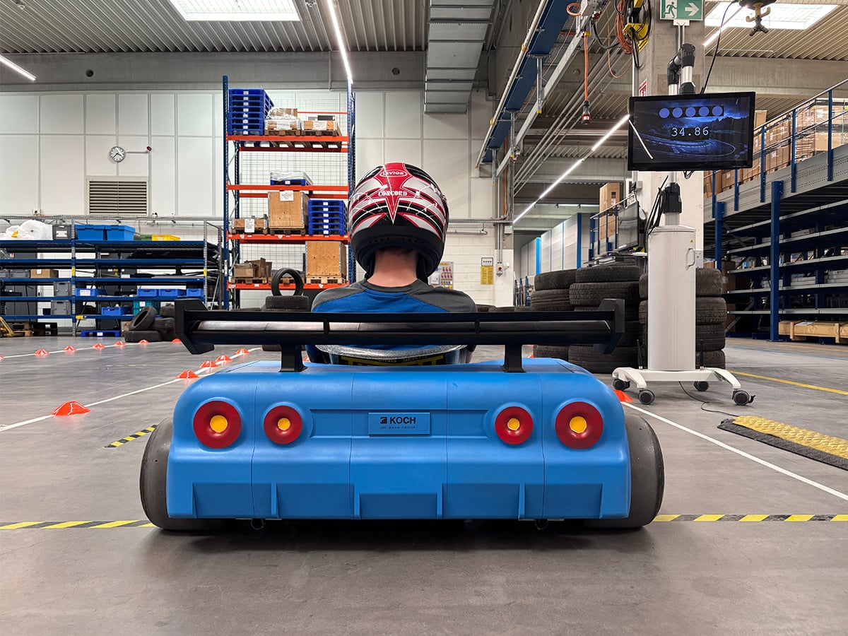 KOCH-branded go-kart built by apprentices as a training project, driven in the production hall of KOCH Pac-Systeme