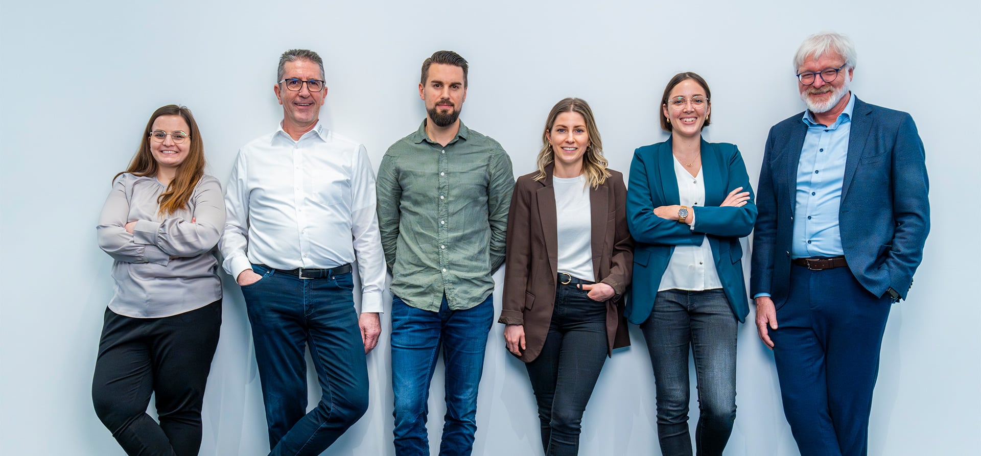 Six KOCH Pac-Systeme employees posing together against a light background, representing career opportunities at the company